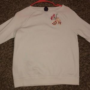 White sweater with colorful flower accents.